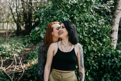 An LGBTQ+ couple sit with each other in Aberdeenshire woodland during their couple photoshoot.