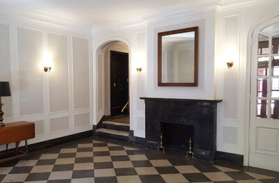 Grand entryway in a luxury NYC apartment building with a fireplace and checkered floors