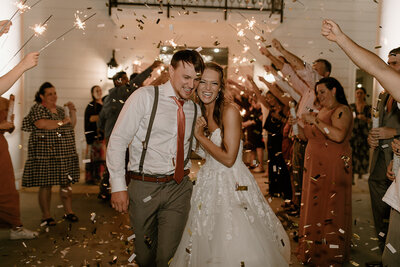 Wedding sendoff with white confetti as couple shares a joyful embrace
