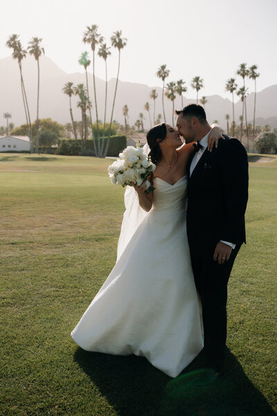 Photo from behind of bride and groom walking towards their wedding guests at their rception