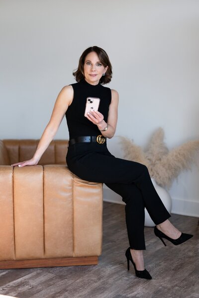 Rebecca resting on the arm of a couch