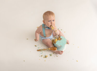 overhead shot of baby eating cake by milestone photographer new philadelphia