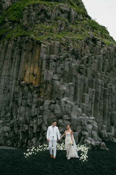 In the midst of an engagement session in a picturesque field, a guy affectionately holds his arms around a girl
