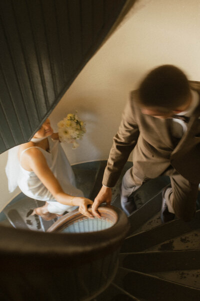 couple holding hands walking up the stairs