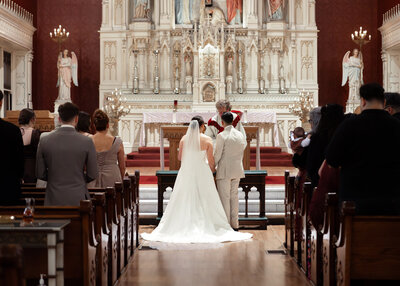 A catholic couple stands at the altar of St. Boniface Catholic Church in downtown Louisville during their fall wedding mass in Kentucky.