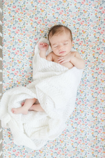 Portrait of mother kissing her newborn baby's cheek.