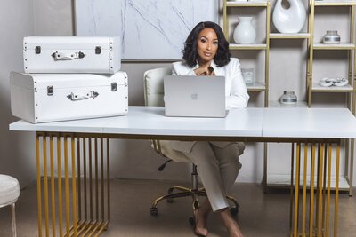Alisha sitting on her desk with her laptop open