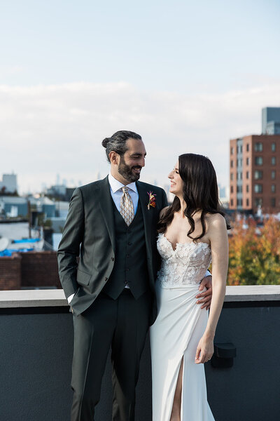 Bride and groom looking at each other with a city backdrop