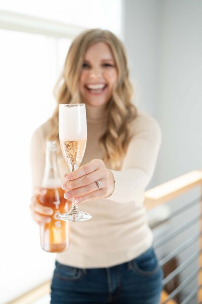woman celebrating holding out glass of champagne