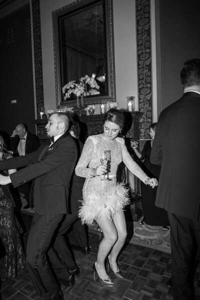 Wedding reception bride is dancing in heels holding champagne 