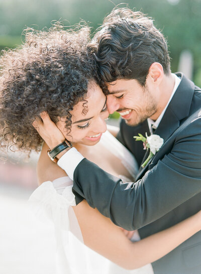 bride and groom embrace while laughing