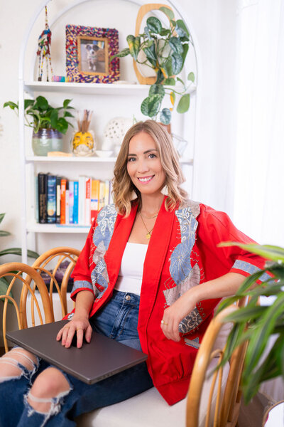 Micaela spinning and laughing in front of a colorful wall at Union Cowork in Encinitas, California