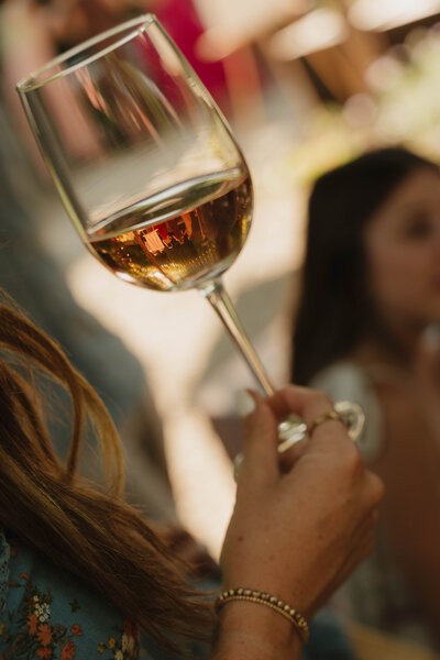 a wine glass with people in the reflection