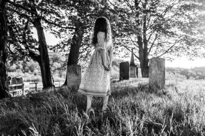 Young girl walking alone in a field near sunset, captured by a hudson valley photographer in Hudson Valley.