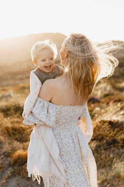 Gezinsshoot tijdens golden hour in de duinen, mama en zoon