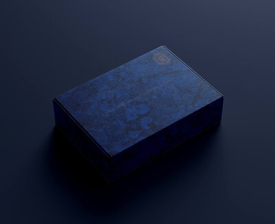 packaging of a closed mailer box for a goldsmith entirely covered in a tone on tone blue marbled paper texture