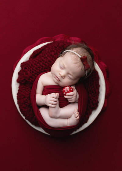 Baby girl swaddled in red during her Newborn session in Southern Minnesota, Greater Mankato newborn photographer.
