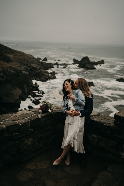 Oregon Coast Elopement Photographer Couple on lookout over the moody coastline of the Pacific Northwest