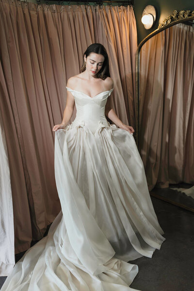 black and white image bride wearing strapless satin wedding dress with long train
