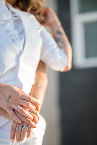 Brides with tattoos holding hands