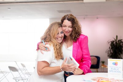 Amanda Hennessey smiling and supporting a coaching client during a one-on-one public speaking session
