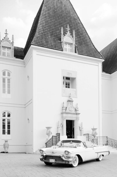 luxury wedding in texas featuring a château venue with a vintage car parked in the front 