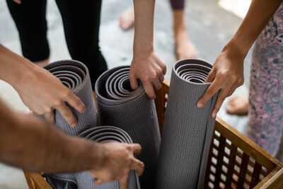 Mehrere Frauen greifen nach Yogamatten in einem Yogastudio