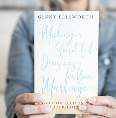 person holding up a book cover to camera