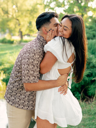 A couple lean their heads close together and close their eyes during their engagement photos at Cheesman Park
