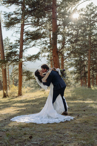 Bride and groom kissing in a dreamy forest in the mountains