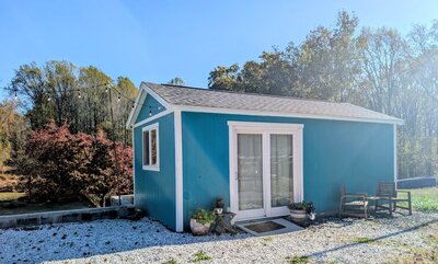 Charm City Craniosacral therapy studio in Ellicott City, Maryland — a peaceful blue cottage surrounded by trees and natural light.