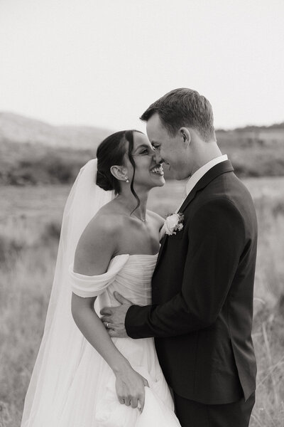 bride and groom kissing on the banks of the madison river in big sky, montana