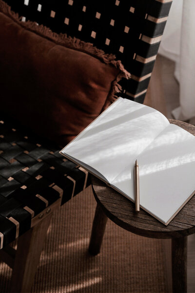 Black chair with blank journal and pen on table