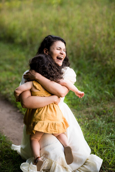 mother embracing her daughter as she runs into her arms