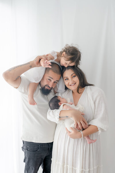 Family of four laughing during Barrie newborn photography session