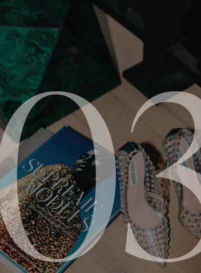 Flat lay of a fashion book and sparkly heels with the number 03 overlaid on top
