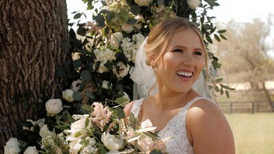 Woman smiles for bridal portraits on her wedding day