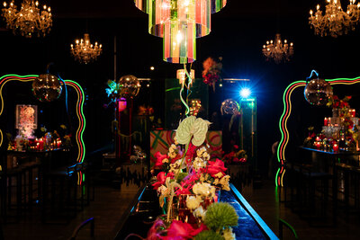 Dark wedding reception with neon colors and bright lights planned by Bloom & Blueprint