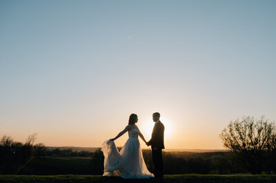 Bride and groom share a first dance while the sun sets behind The Stables at Copper Ridge in Denison, IA. Photo by Anna Brace, who specializes in Nebraska Wedding Photography.