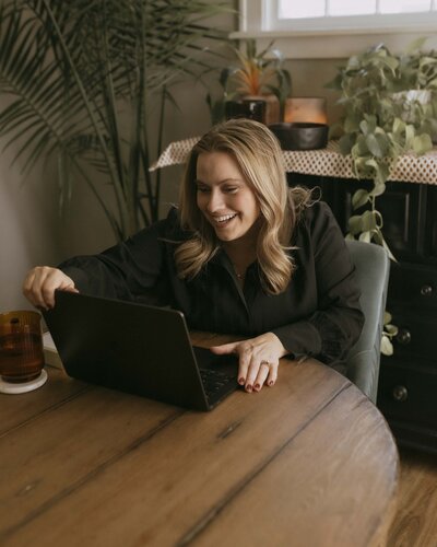 Renee smiling at laptop