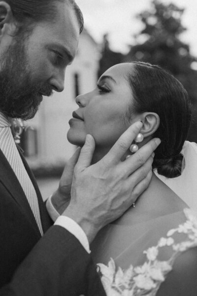 Romantische trouwfoto van een bruid en bruidegom die elkaar liefdevol aankijken tijdens een bruiloft.