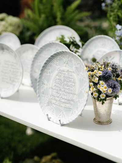Blue and white plates with grey calligraphy for seating chart at Lion Rock Farm wedding