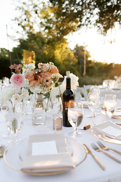 Close up of wedding table setting with flowers, wine glasses, dinner plates and napkins