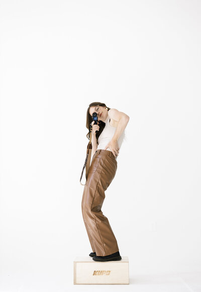 videographer with camera stands on wood block