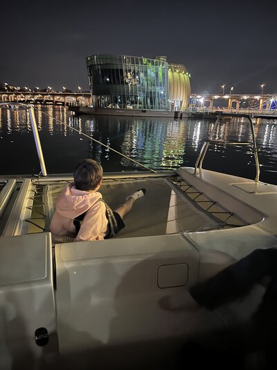 Kid on boat in Seoul’s Han River at night — real-life expat reflections from the Growing Up Expat series on Leaving Main Street