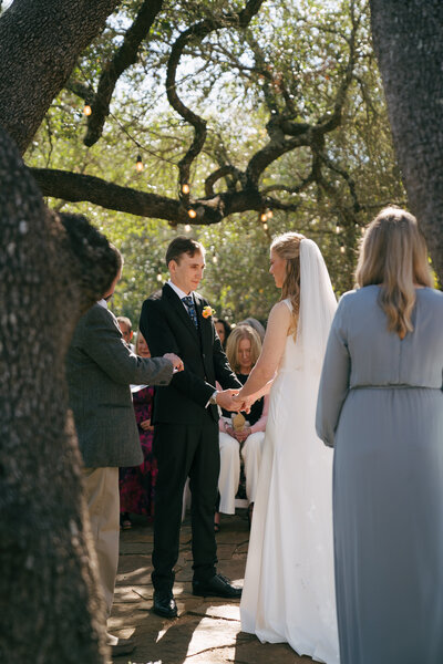bride and groom saying their vows at an outdoor ceremony 