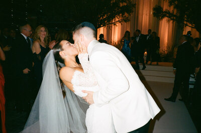 a bride and groom kiss on a dancefloor
