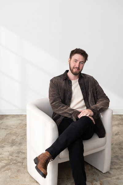 Associate at SDK William sitting in white chair in bright room