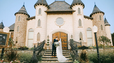 Bride and Groom kissing in front of Wadley Farms Castle on front steps taken by Cali Warner Media