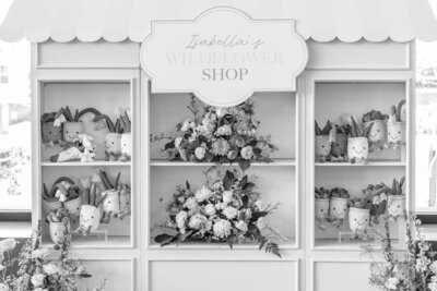 Black and white image of party favor wall of stuffed succulents for birthday party planned by Fancy Chancey in San Diego CA